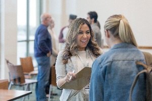 two women speaking with each other in a classroom setting