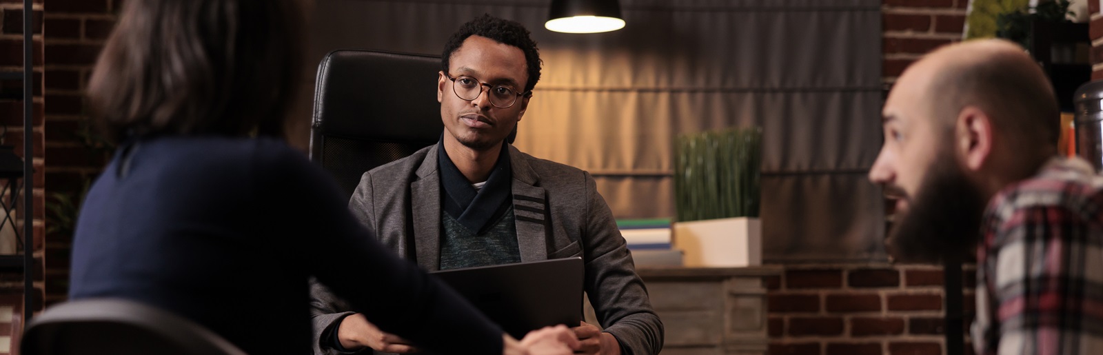 counselor meeting with a man on a couch and woman in a chair in an office