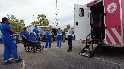 south university healthcare students listening to a disaster relief expert outside the back of one of the disaster relieve vehicles