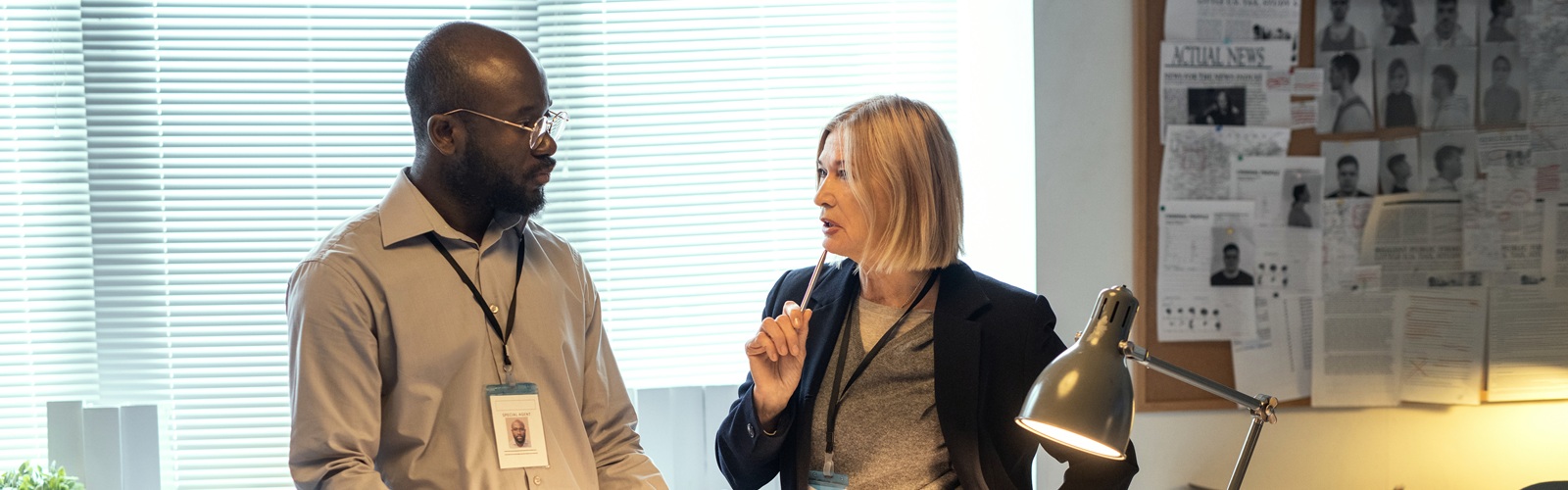 man and a woman intently discussing the paperwork on the desk