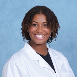 Genell O Keefe headshot in a white lab coat and dark shirt