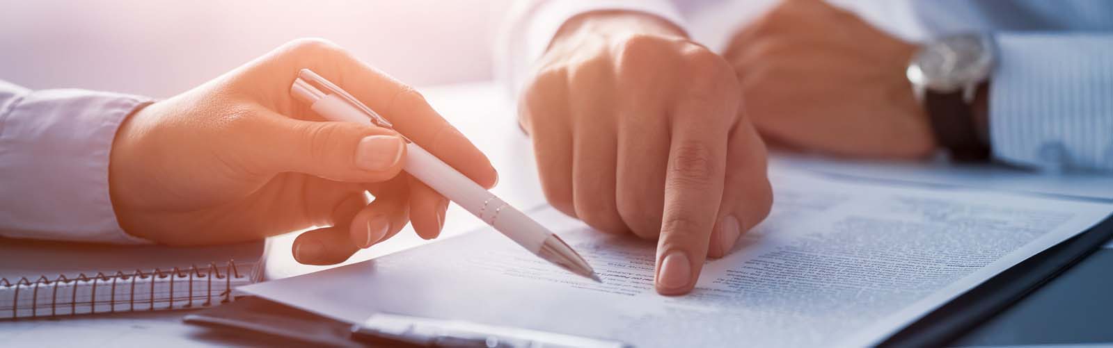 two people discussing paperwork attached to a clipboard
