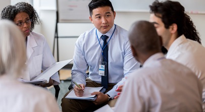 group of professionals, all races, gathered in a circle, having a discussion