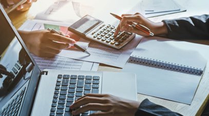 Accountants adding up figures with a calculator on desk-alt-text
