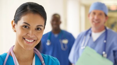 Female medical practitioner in front of doctor and nurse smiling-alt-text