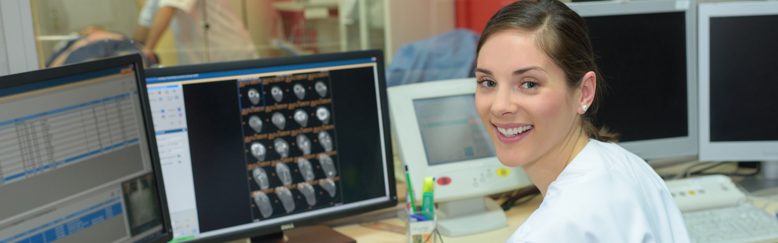 Female nurse in front of computer screen smiling