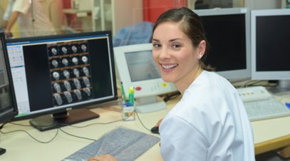 Female nurse in front of computer screen smiling-alt-text