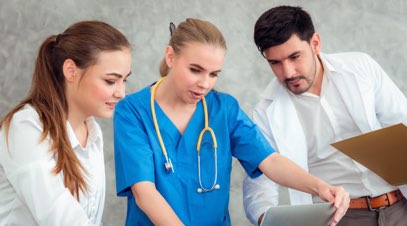 Nurses and doctor looking at laptop-alt-text