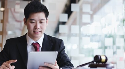 Male paralegal reviewing documents on tablet-alt-text
