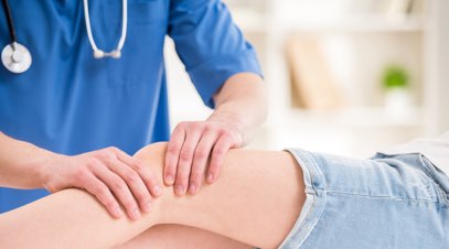 Physical therapist massaging patient's knee-alt-text