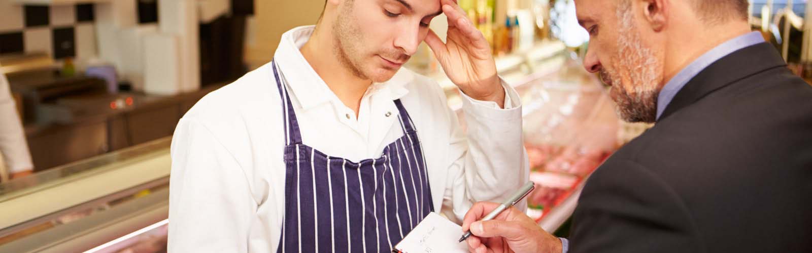 Health inspector writing notes to restaurant owner