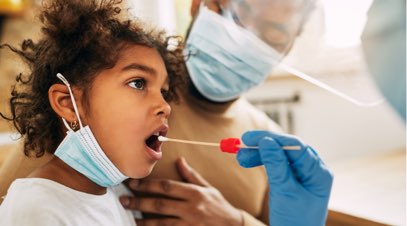 Healthcare professional swabbing child's mouth as parent watches-alt-text