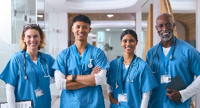 2 women and 2 men in their medical scrubs standing in a hospital hallway